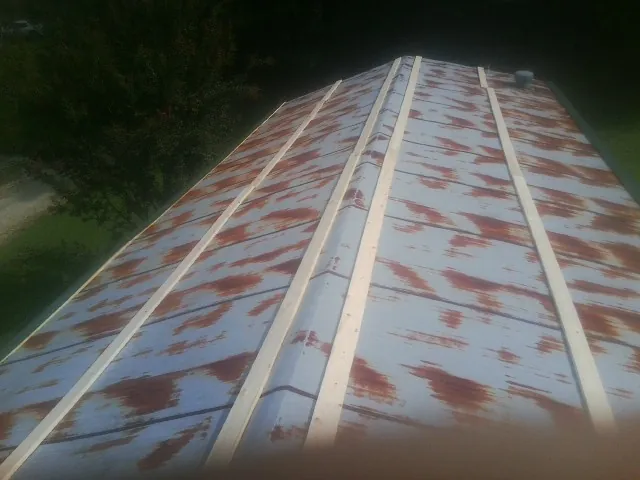 Rusted metal roof panels with new wood purlins before replacement — Storm Damage Roof Repair in Archer by Roofing Brothers